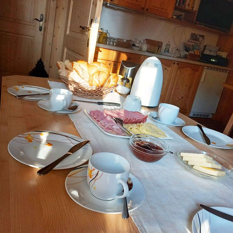 Gedeckter Tisch mit Frühstück mit Wurst, Käse, Gebäck